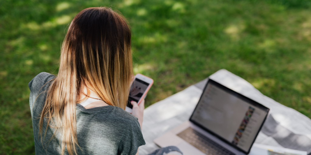 woman checking social media on grass
